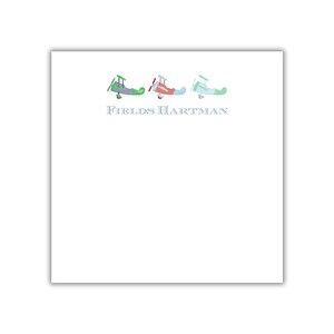 Peut inclure: Trois petits avions jouets alignés. Les avions sont rouge, vert et bleu avec des motifs à carreaux blancs et bleus. Le texte "FIELDS HARTMAN" est sous les avions.