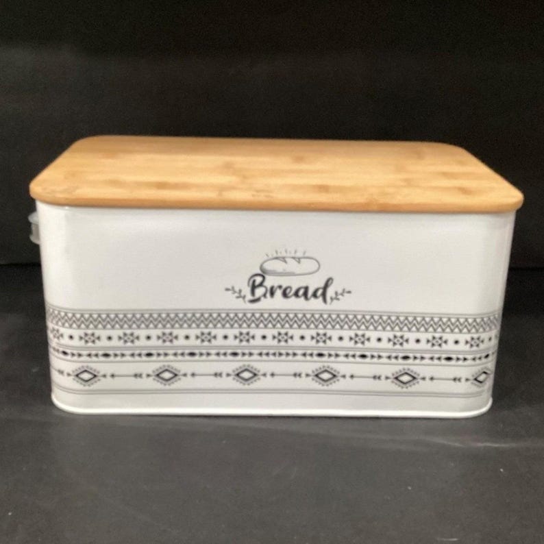 Front-facing product shot of the white metal bread box with its wooden lid.