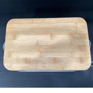 A top-down close-up shot of the bamboo lid resting on top of the bread box.