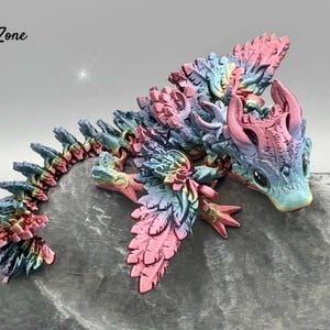 Bébé dragon lunaire avec des ailes aux couleurs de l'arc-en-ciel