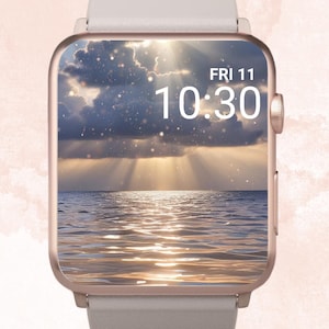Peut inclure: Une montre connectée avec un bracelet gris clair et un cadran d'horloge numérique affichant l'heure 10h30. Le cadran de l'horloge montre une image d'un ciel nuageux avec des rayons de soleil qui brillent à travers les nuages et se reflètent sur l'eau de l'océan.