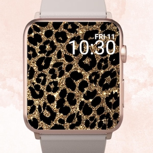 Può includere: Un quadrante di orologio con stampa leopardata dorata glitterata con un cinturino bianco e un orologio digitale che mostra "FRI-11 10:30".