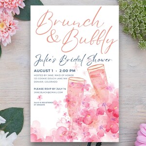 Puede incluir: Una ilustración acuarela rosa y blanca de copas de champán con flores rosas. El texto dice "Brunch & Bubbly Julie's Bridal Shower 1 de agosto, 2:00 PM Anfitriona: Jane, dama de honor 123 Cookie Dough Lane NW Denver, Colorado Por favor, responde antes del 14 de julio Jane.Black@gmail.com Julie está registrada en Amazon"