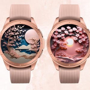 May include: Two rose gold smartwatches with pink bands. The watch faces display a cherry blossom scene with a full moon. The text "Babe in Bloom CREATIONS" is at the top.
