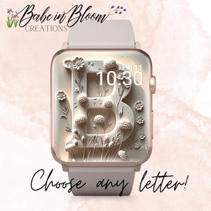 May include: A rose gold smartwatch with a floral design featuring the letter "B" and the text "Choose any letter!". The watch face displays the time as 10:30 on Friday, the 11th. The watch band is a light pink colour.