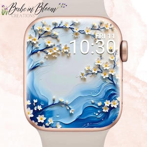 Peut inclure: Une montre connectée avec un boîtier en or rose et un bracelet en silicone blanc. L'écran numérique affiche un fond blanc avec des vagues bleues et des branches de cerisier blanches. L'heure 10:30 et la date FRI 11 sont visibles.