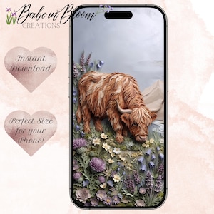 May include: A smartphone displaying a digital wallpaper featuring a shaggy brown Highland cow grazing in a field of purple and white wildflowers. The background includes soft mountain shapes and a light blue sky, presented on a modern mobile device.