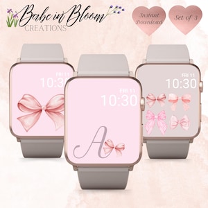 May include: Set of three pink and gold watch faces with a bow design. The watch faces display the time as "FRI 11 10:30". One watch face features a large letter "A" with a bow.