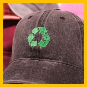 Może przedstawiać: Ciemnoszara czapka z daszkiem z haftowanym zielonym symbolem recyklingu z przodu.