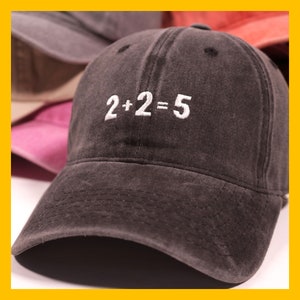 May include: A dark grey baseball cap with a white embroidered design that reads "2+2=5".