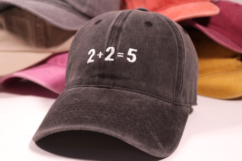 May include: A black denim baseball cap with white embroidery that reads "2+2=5".