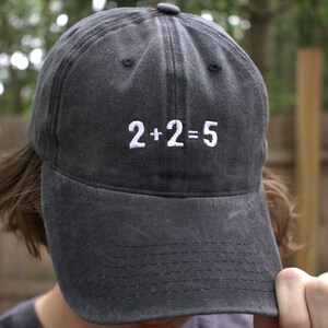 May include: A black baseball cap with white embroidery that reads "2+2=5".