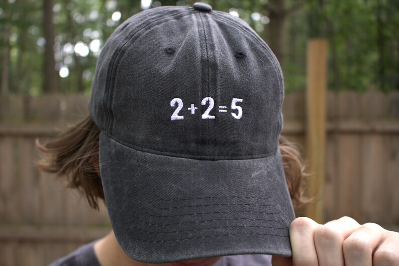 May include: A black baseball cap with white embroidery that reads "2+2=5".