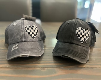Gorro de mujer con coleta desgastada y corazón a cuadros.