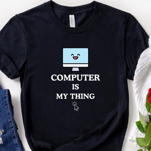 Puede incluir: Camiseta negra con un monitor de ordenador de dibujos animados blanco con una cara sonriente y el texto "COMPUTER IS MY THING" con una flecha de cursor blanca.