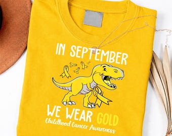 in September We Wear Gold Childhood Cancer Awareness Dinosaur Shirt