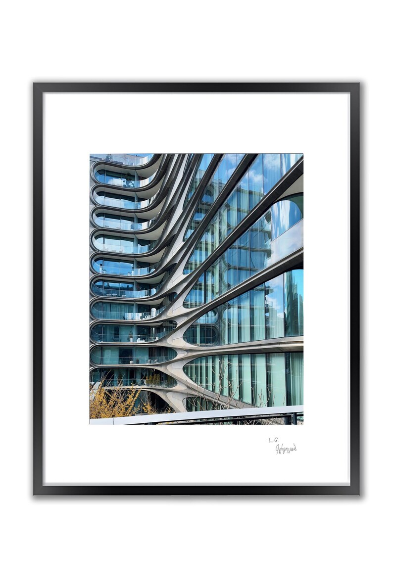 A framed color photo shows a modern building with wavy, horizontal lines and many windows reflecting the sky.