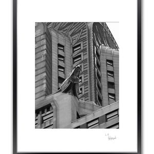 A framed black and white photo shows a close-up of the upper section of a building with a large gargoyle sculpture.