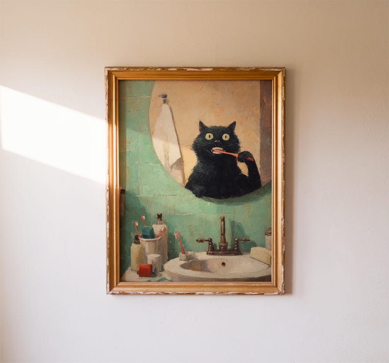 K&ouml;nnte beinhalten: Ein gerahmtes Gem&auml;lde zeigt eine schwarze Katze, die sich in einem Badezimmerspiegel die Z&auml;hne putzt. Die Katze befindet sich vor einer gr&uuml;n gefliesten Wand, mit einem Waschbecken und Toilettenartikeln. Das Gem&auml;lde hat einen goldenen Rahmen und h&auml;ngt an einer wei&szlig;en Wand.