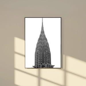 May include: Black and white photograph of the Chrysler Building, a prominent Art Deco skyscraper in New York City. The image captures the building's distinctive tiered crown and spire against a bright white background, framed in a black border.