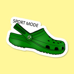 May include: Green and black Crocs shoe with the text "SPORT MODE" on the strap.