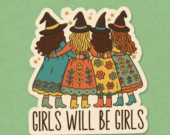 May include: A sticker featuring four cartoon witches in colorful dresses and witch hats, hugging each other. The dresses are teal, orange, yellow, and teal, with floral and leaf patterns. The text "GIRLS WILL BE GIRLS" is at the bottom.