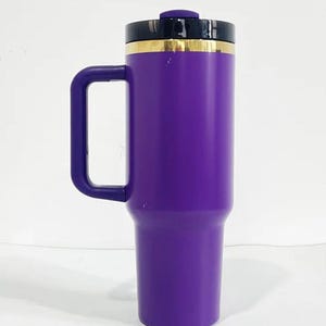 May include: A purple travel mug with a black lid and a gold band around the top. The mug has a handle and is made of stainless steel.