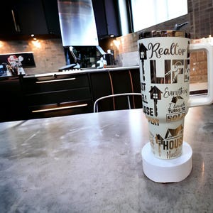 May include: White travel mug with a gold design that says "Realtor Life" and "Everything I Touch Turns To Sold".