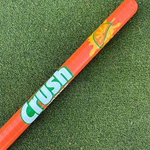 May include: Orange and green inflatable pool float shaped like a Crush soda can with the word "Crush" printed on the side. The float has a graphic of an orange slice with orange juice dripping down the side.