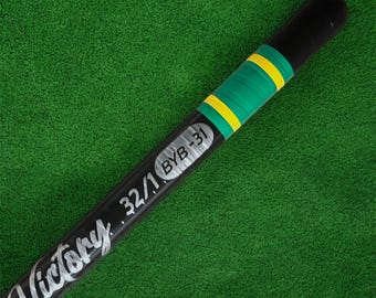 May include: A black baseball bat with the word "Victory" in white script. The bat has a green and yellow grip and the text "32/1 BYB-31". The background is green.
