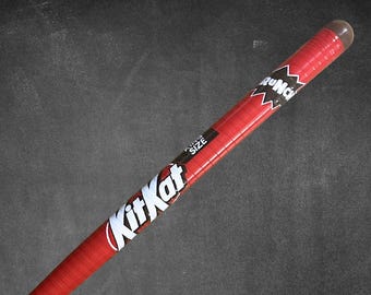 May include: A red Kit Kat candy bar with the text "Kit Kat" in white and a "King Size" label. The candy bar is wrapped in red packaging with a clear plastic end.