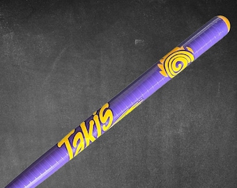 May include: A cylindrical purple container with the word "Takis" in yellow, stylized lettering. The container has a yellow spiral design and a yellow cap. The background is a dark gray surface.