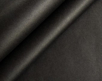May include: Close-up of a black fabric with a smooth, silky texture. The fabric is folded in half, creating a diagonal line.