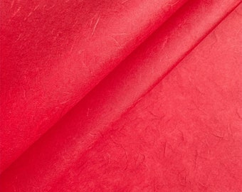 May include: A close-up of red tissue paper with a textured, crinkled surface.
