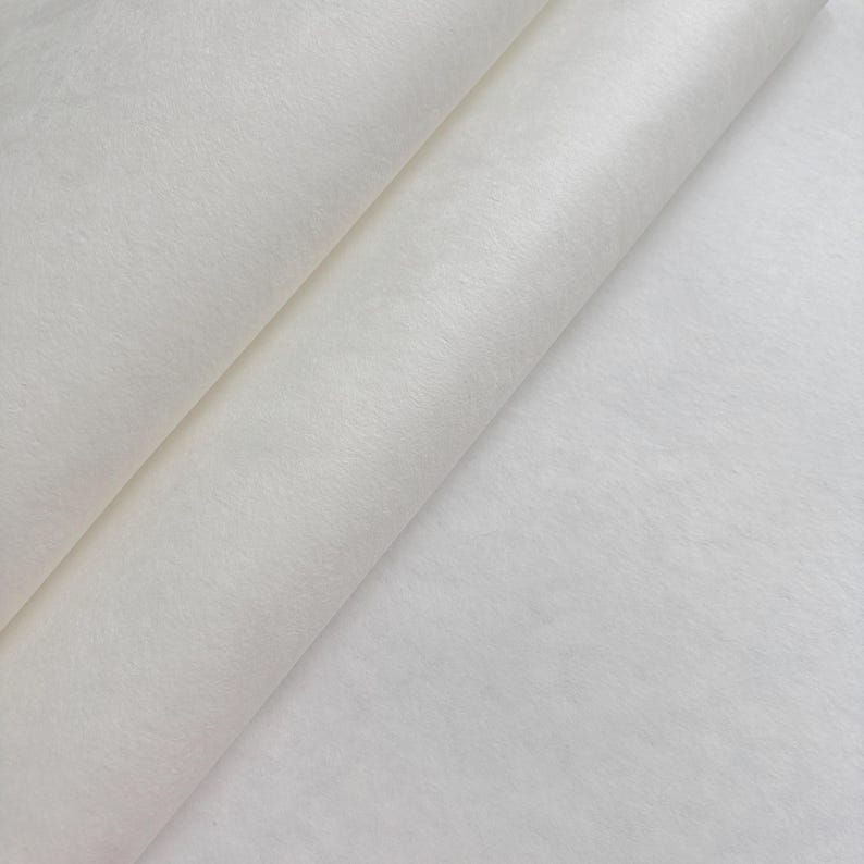 Puede incluir: Primer plano de una tela blanca rota doblada. El material parece suave y texturizado, con sutiles variaciones de tono. Los pliegues crean sombras y profundidad, resaltando la delicada naturaleza de la tela. La impresi&oacute;n general es de textura suave y color neutro.