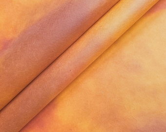 May include: A close-up of a piece of orange and brown textured paper. The paper is folded in half, creating a diagonal line across the image.