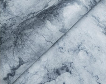 May include: A close-up of a gray and white marble-patterned fabric. The fabric has a soft, textured surface and a subtle sheen.