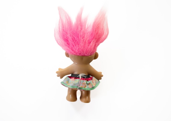 ピンクの髪とカラフルなプリントのスカートをまとったヴィンテージの