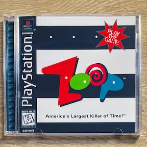 Puede incluir: Caja de videojuego de PlayStation con un diseño colorido. La portada presenta la palabra "Loop" en rojo, verde y azul, con el texto "Play the Game!" en una estrella roja. El juego está clasificado "KA" para mayores de 6 años y se titula "America's Largest Killer of Time!"