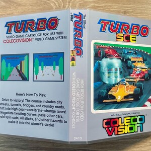 May include: A Turbo SCE video game cartridge for the ColecoVision console. The box art features a racing scene with multiple cars on a track. The cartridge includes instructions on how to play the game. The game is by Sega.