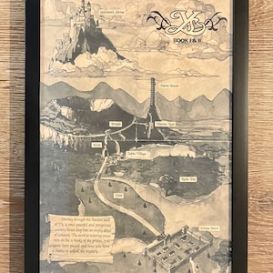 May include: Framed black and white map illustration of a fantasy landscape with text. The map features locations like Solomon's Shrine, Darm Tower, and Thieves Nest. Text at the bottom describes a journey through the land of Y's. The frame is black.