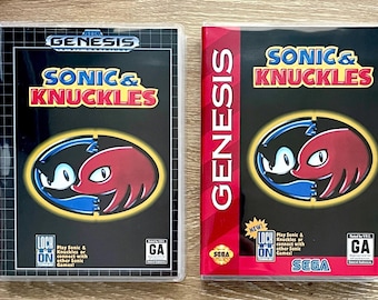 May include: Two Sega Genesis video game cases for Sonic & Knuckles. Both feature black covers with the title in yellow and red, and a central circular graphic showing Sonic and Knuckles. Each case includes the Lock-On technology logo and GA rating.