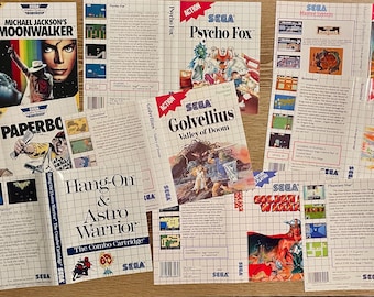 May include: A collection of Sega Master System game boxes and inserts, including titles like "Michael Jackson's Moonwalker," "Paperboy," "Psycho Fox," and "Phantasy Star." The boxes feature colorful game art and the Sega logo.