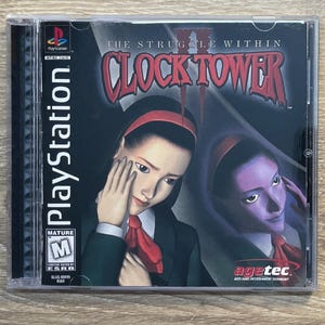 Puede incluir: Caja de juego de PlayStation para "Clock Tower II: The Struggle Within". La carátula presenta a dos mujeres con cintas para el pelo y corbatas rojas, con el título del juego en una fuente gótica roja. La caja está en una caja de plástico transparente.