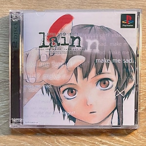 May include: A Serial Experiments Lain PlayStation video game case with a 2-disc label on the side. The cover features a character with brown hair and large eyes, a hand with a red mark, and text including make me sad and make me mad.