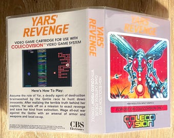May include: A ColecoVision video game cartridge for "Yars' Revenge." The box features the game's title in orange, a retro game screen, and a futuristic illustration of a robotic figure with wings. The game is for use with the ColecoVision video game system.