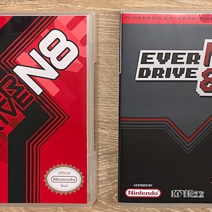 May include: Two video game cases. The left case is red with black diagonal lines and the text "EVER DRIVE N8" in white. The right case is black and gray with the text "EVER DRIVE N8 PRO" in white. Both cases have the Nintendo logo.