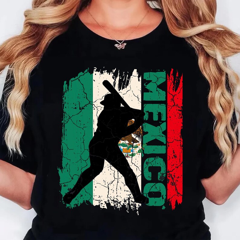 May include: Black t-shirt with a distressed Mexican flag design and a baseball player silhouette. The word "MEXICO" is printed vertically in green and red. The shirt has a crew neck.