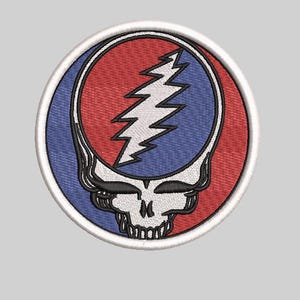 May include: Embroidered patch featuring a stylized skull with a lightning bolt. The design incorporates red and blue sections within a white circular border. The skull has a detailed, black outline.