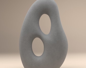 Pode incluir: Uma escultura cinza abstrata com duas aberturas ovais. A forma lisa e arredondada tem uma superfície texturizada e fica em um fundo neutro. Esta peça decorativa pode ser usada como um toque moderno para a casa.